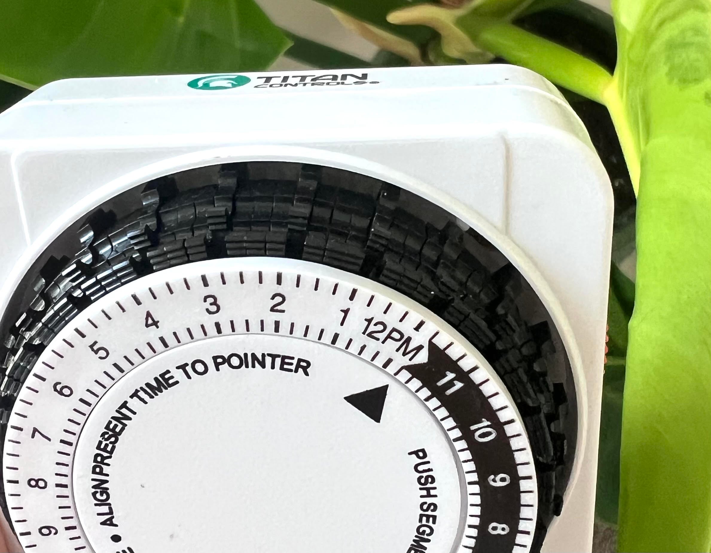 Plug-in timer with the first lever of every hour pushed down and the switch set to Timer